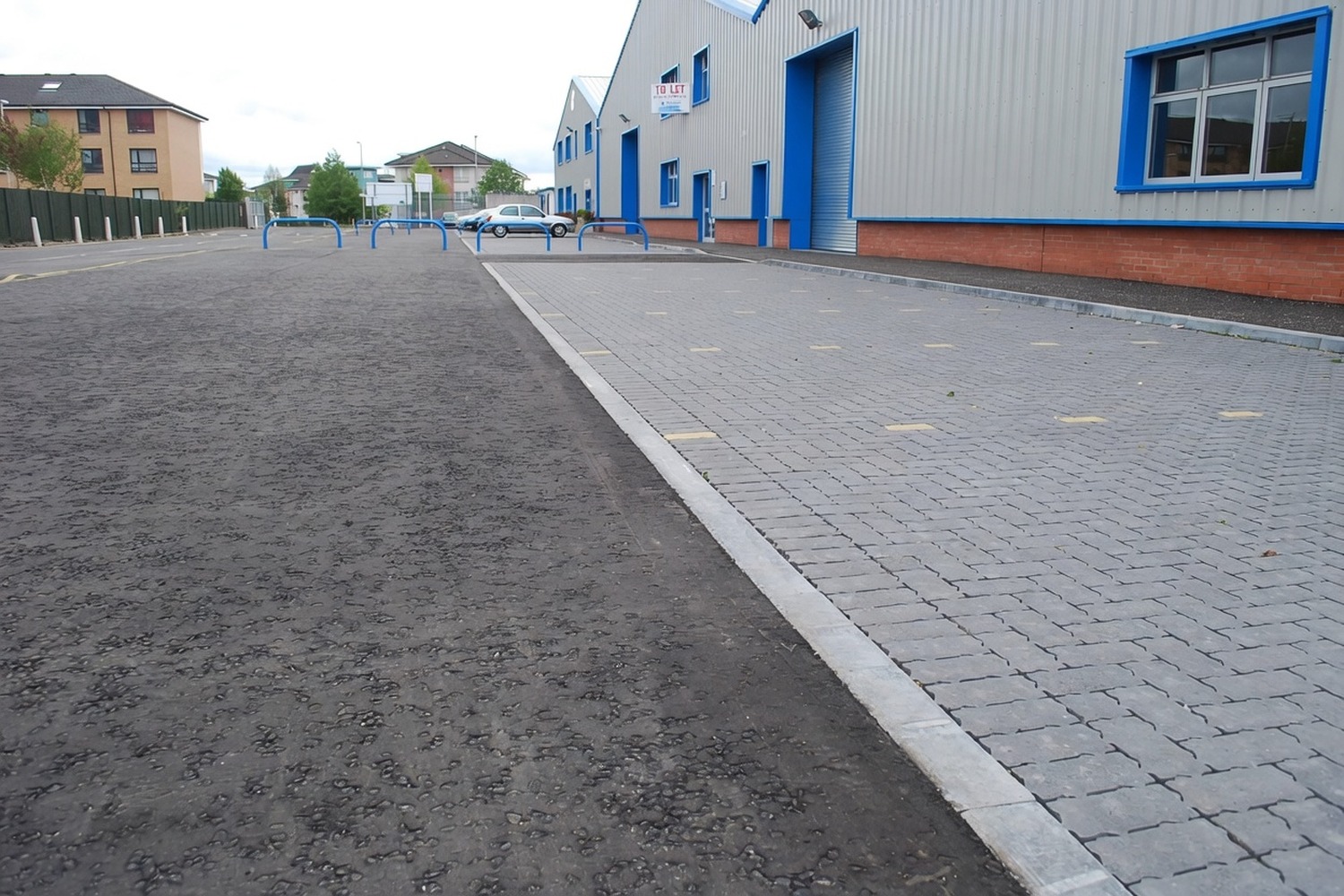 Finished commercial car park with crisp asphalt surface and block-paved bays