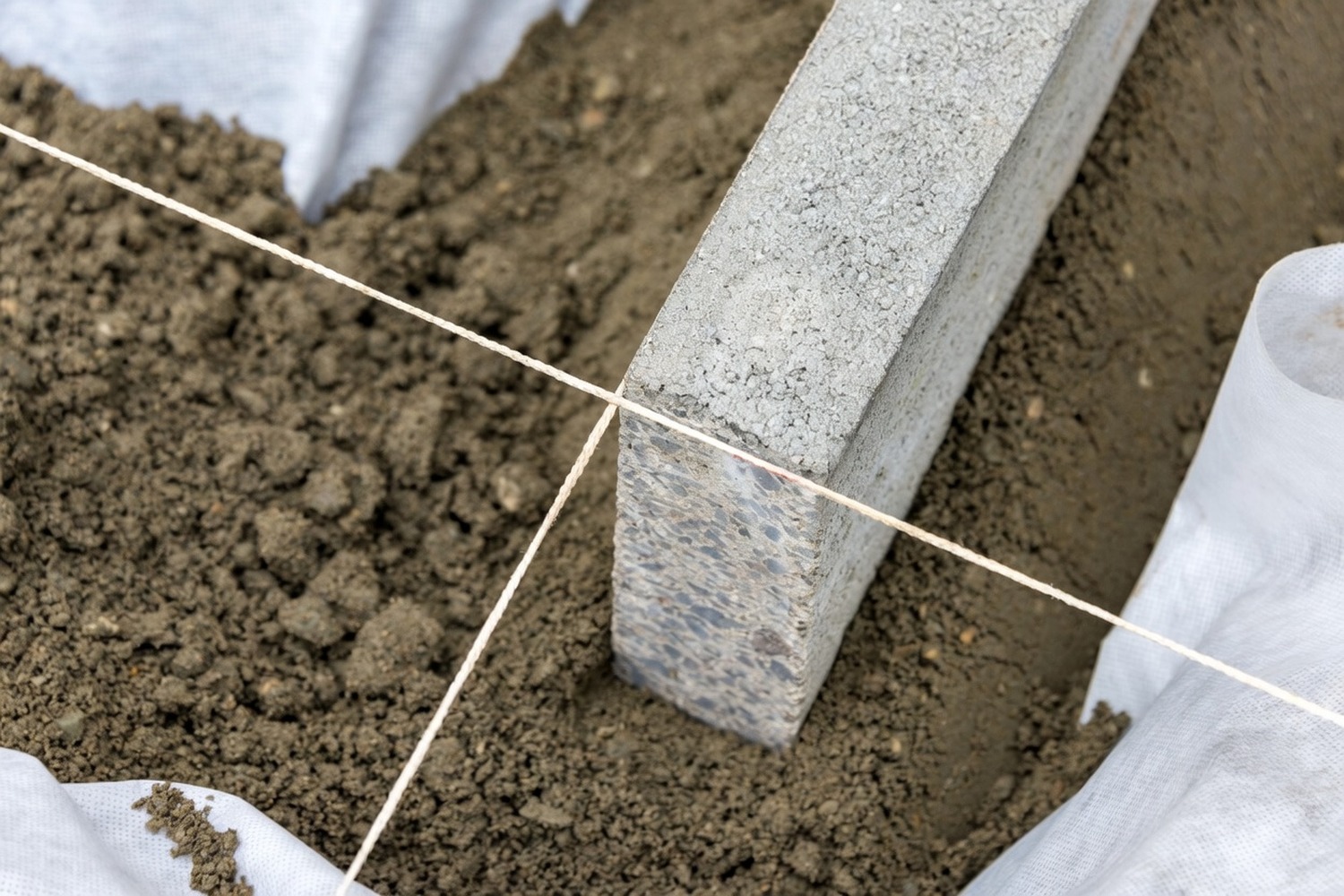 Concrete block kerbing being set to a string line