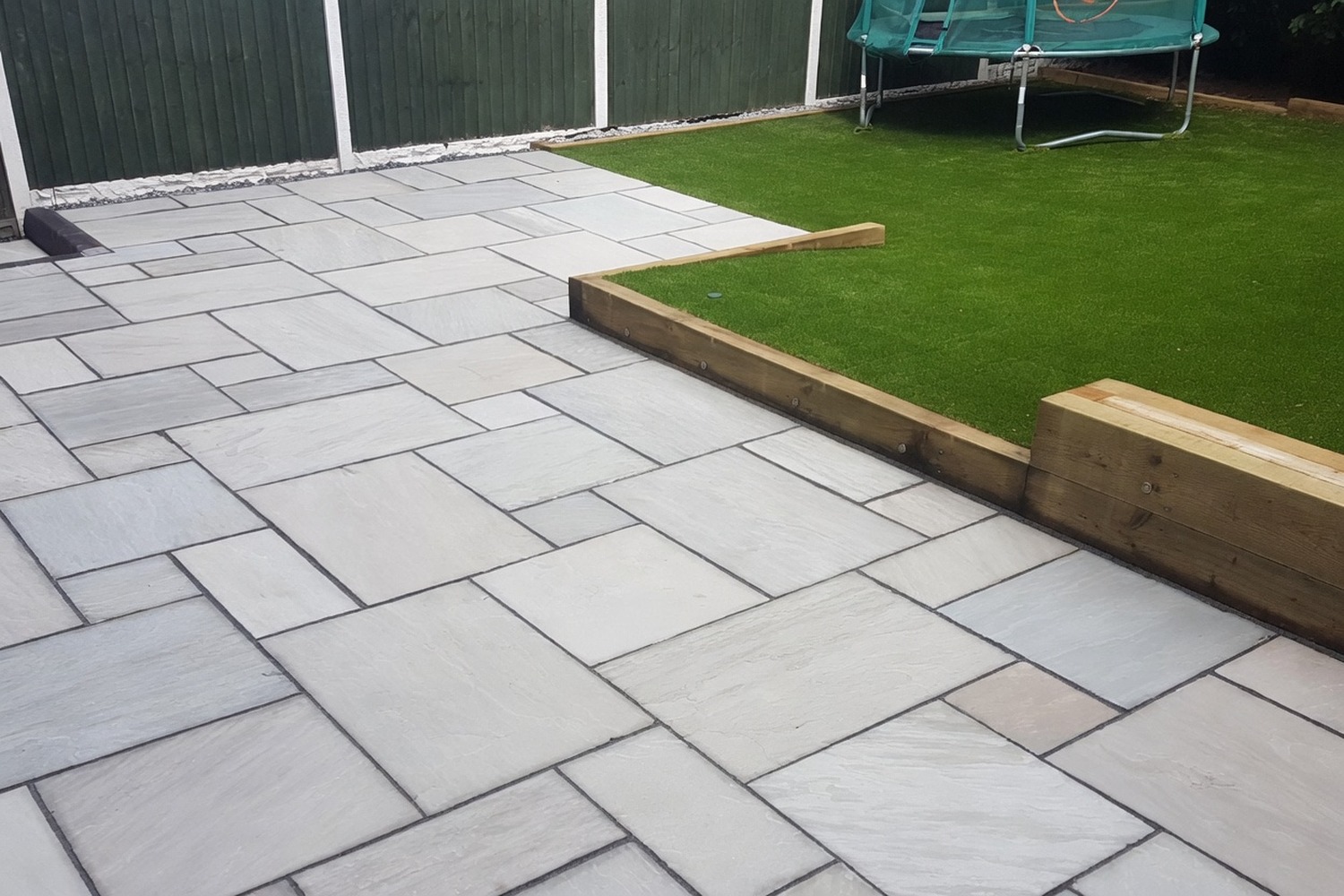 White-slab patio bordered by artificial grass