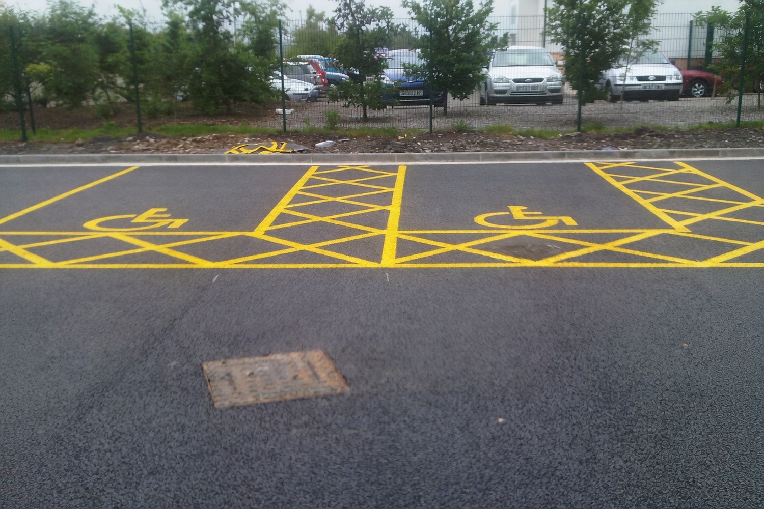 Disabled parking bay marked with the wheelchair symbol and a yellow access-grid hatch