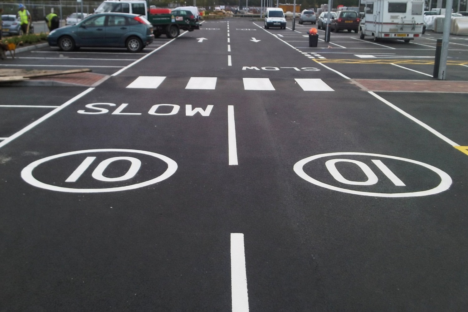 SLOW 10 mph road markings on a tarmac access road