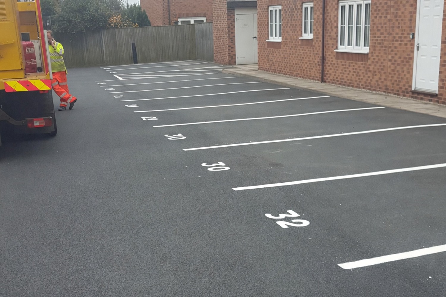 Numbered parking bays — 30, 31, 32 painted on a finished tarmac surface