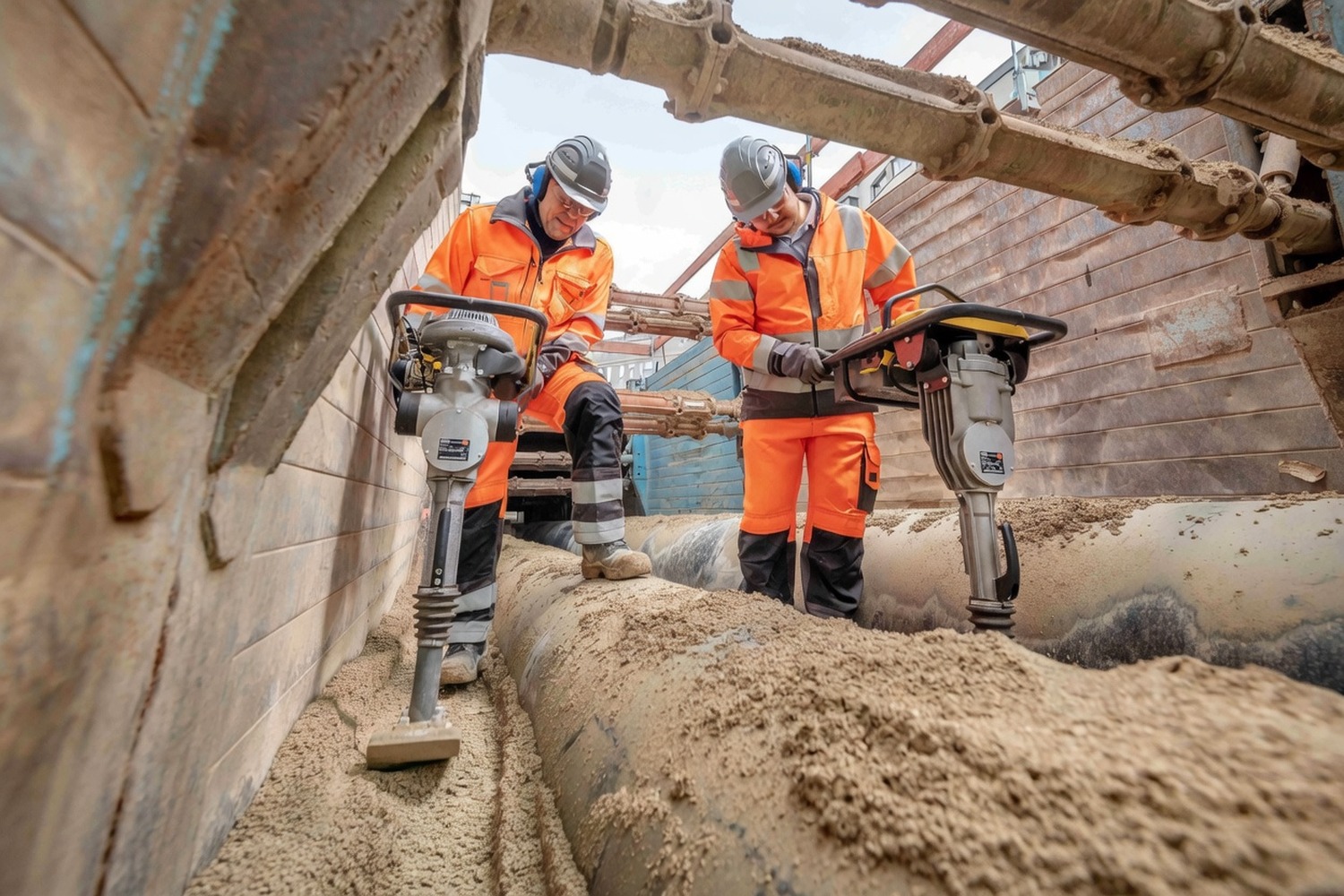 Two operatives breaking out road surface with jackhammers